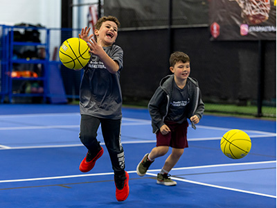 Elementary aged kids engaged in a basketbal training game