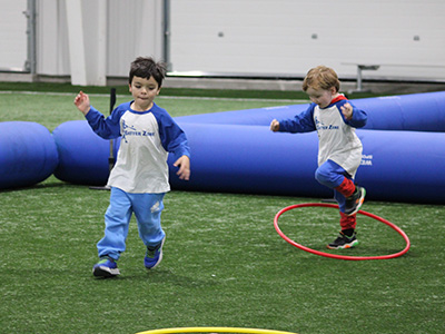 2 young kids playing a baseball game together