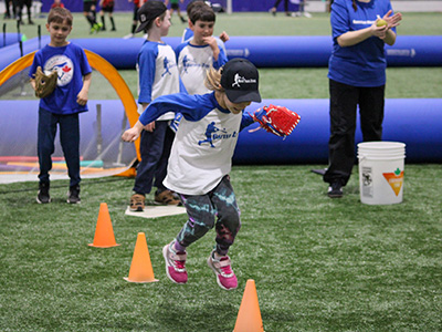girl jumping over cones and completing a coordination drill