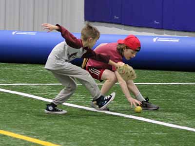 2 kids racing for a out field ball