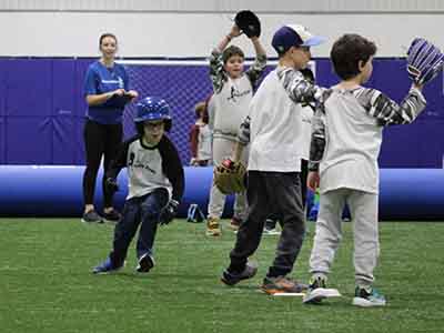 Child running bases while opposing teams tries to catch a pop-fly