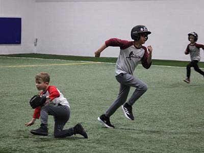 Kids running bases while fielding balls